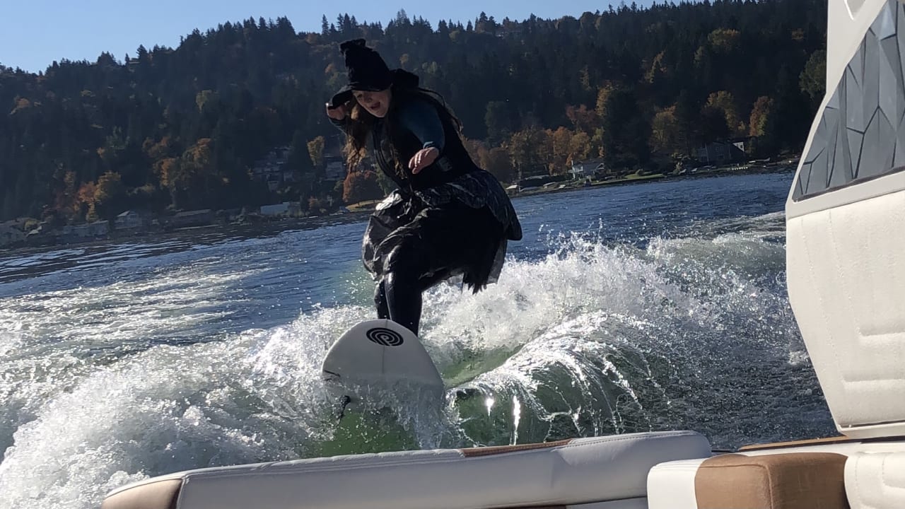 a woman wearing a witch attire riding a waveboard