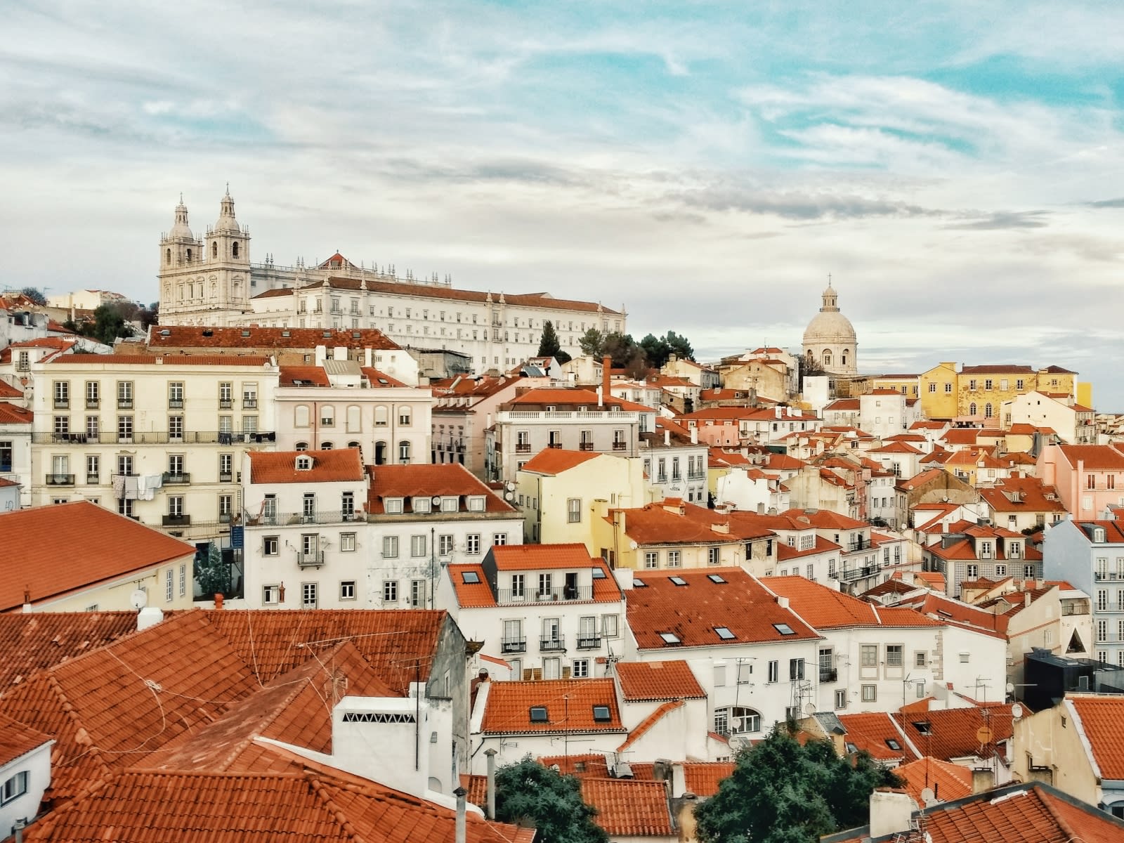 Lisbon rooftops with São Vicente de Fora and the National Pantheon rising above the historic neighborhood.