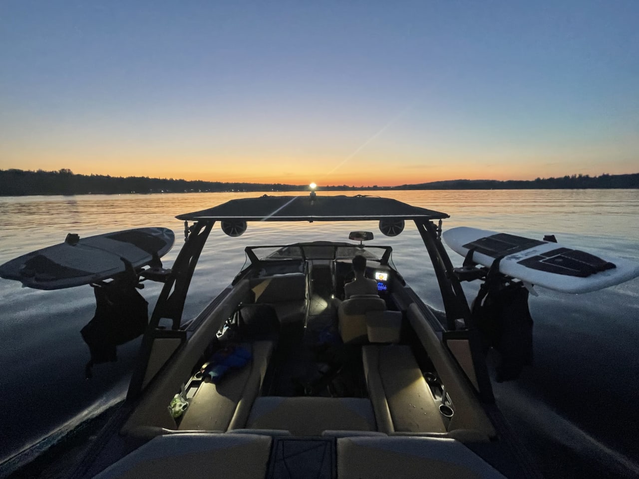 a man driving a luxury yatch on a lake