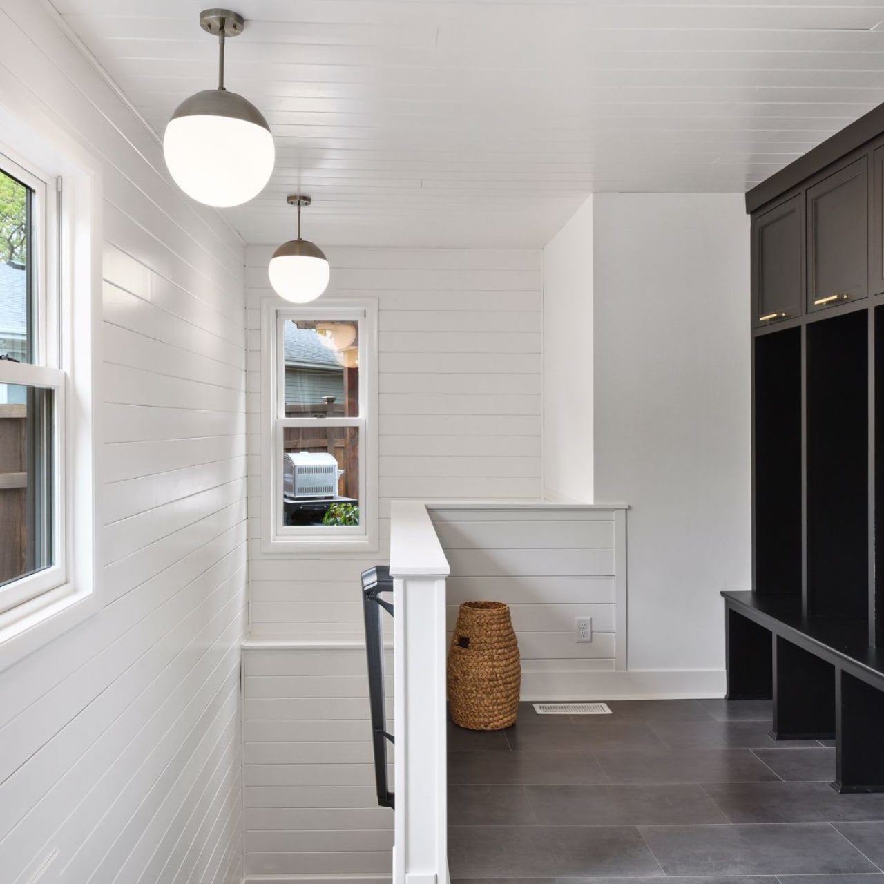 A hallway with white walls and black cabinets with chrome handles.