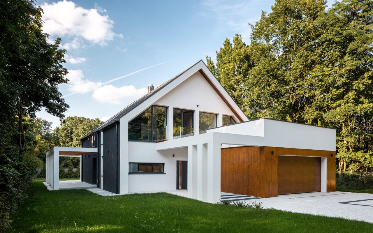 A modern, two-story house with a white exterior and a black roof.