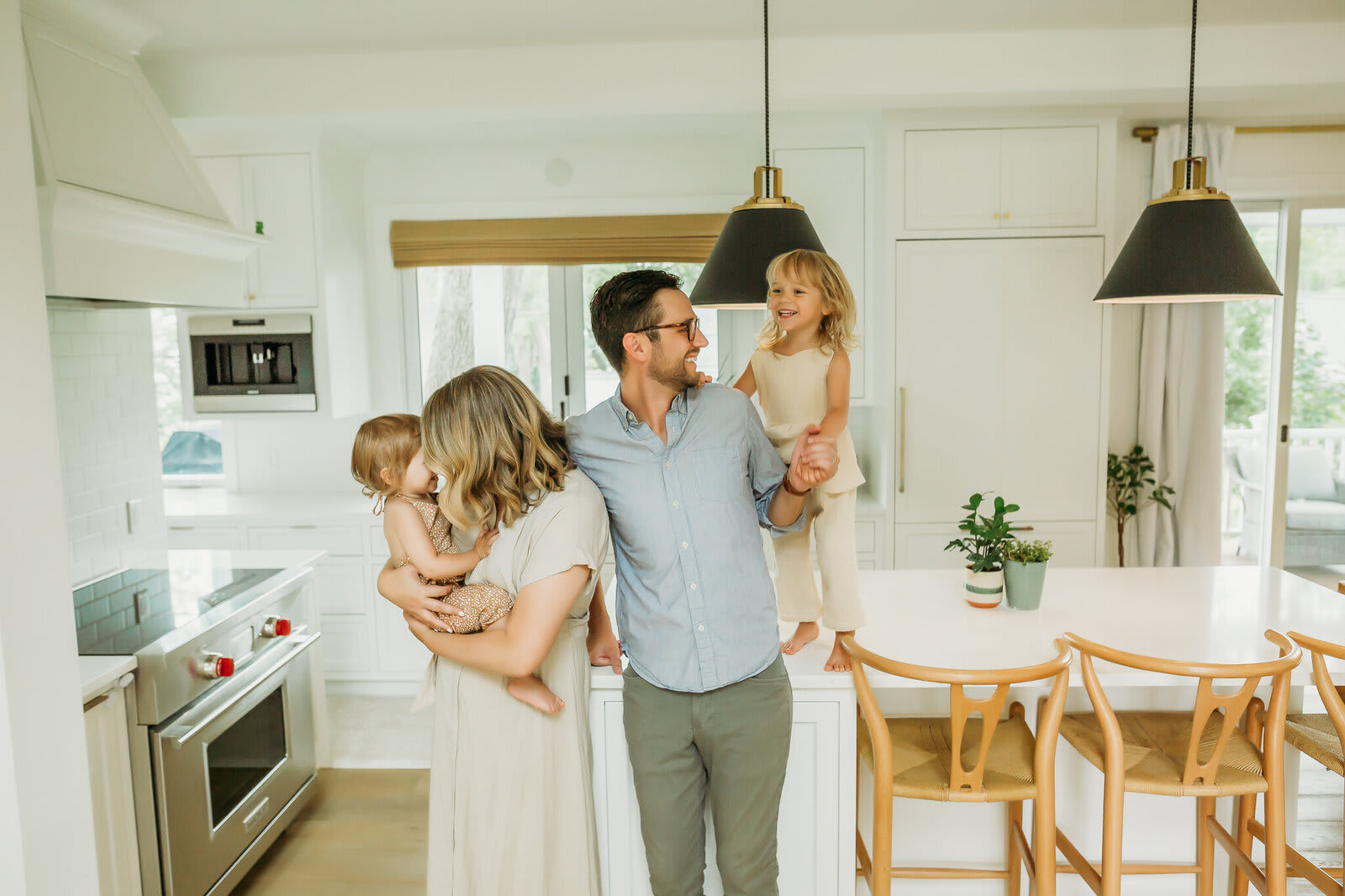 A family gathers in a kitchen with a white kitchen island.