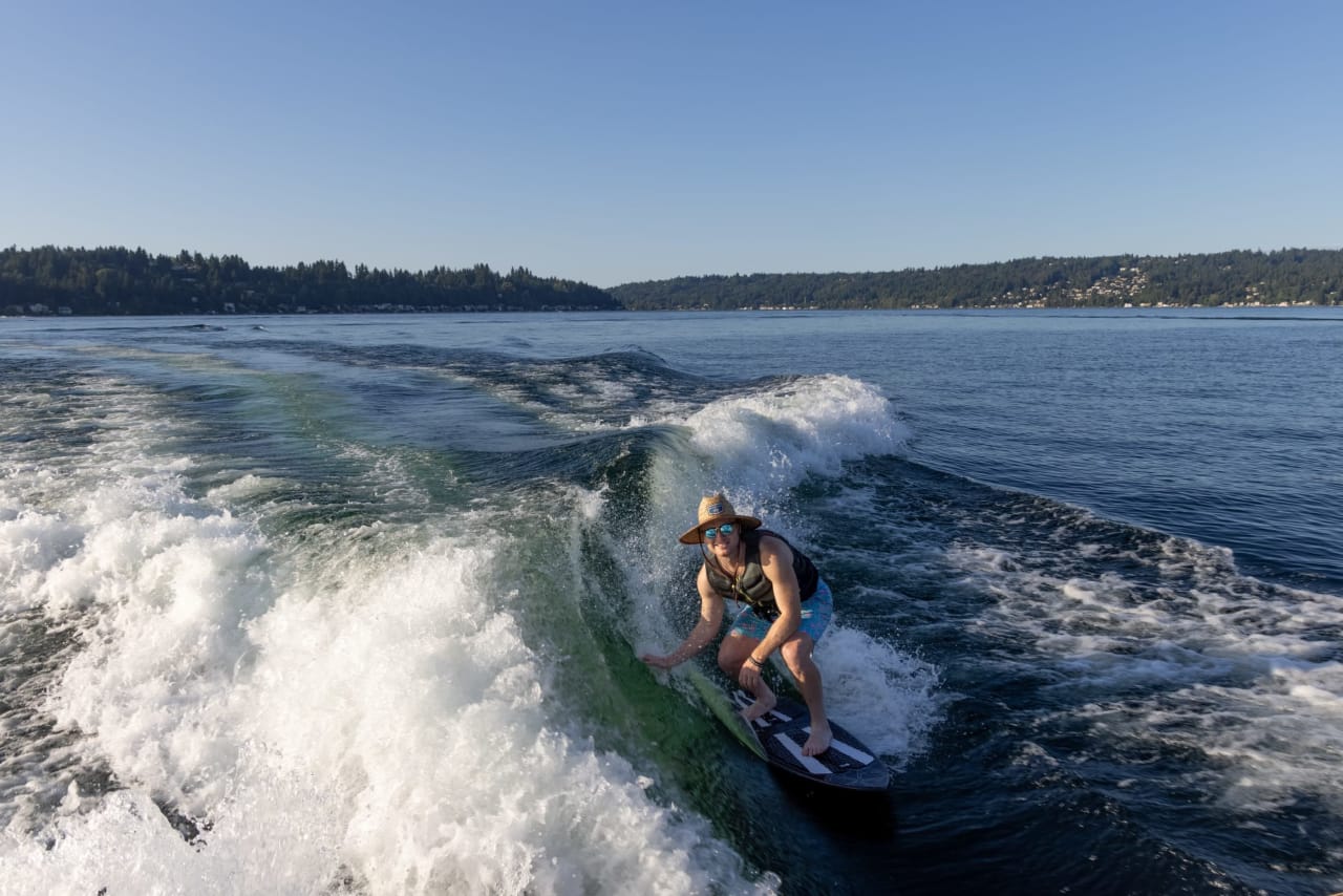 happy man riding surfboard in a crashing waves