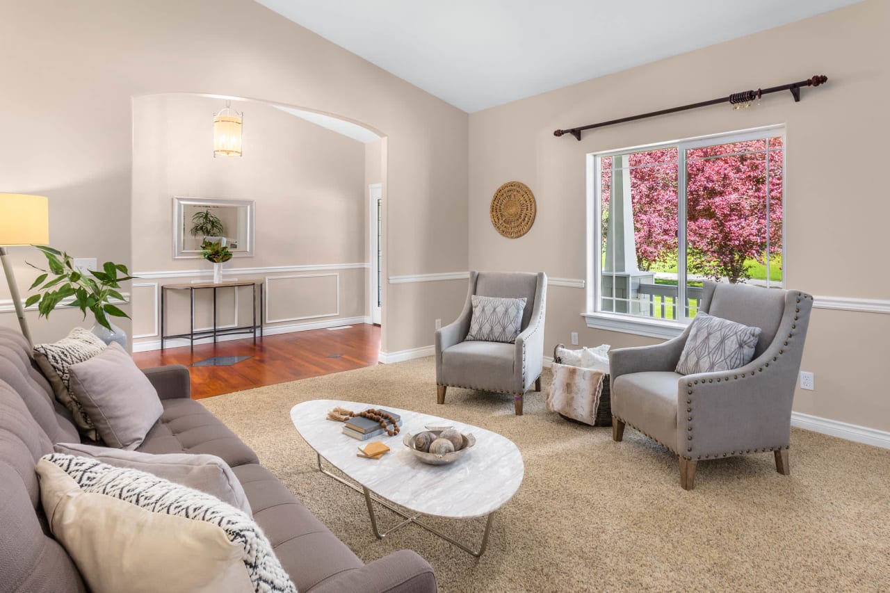 A cozy living room with a gray sofa, two armchairs, and a coffee table