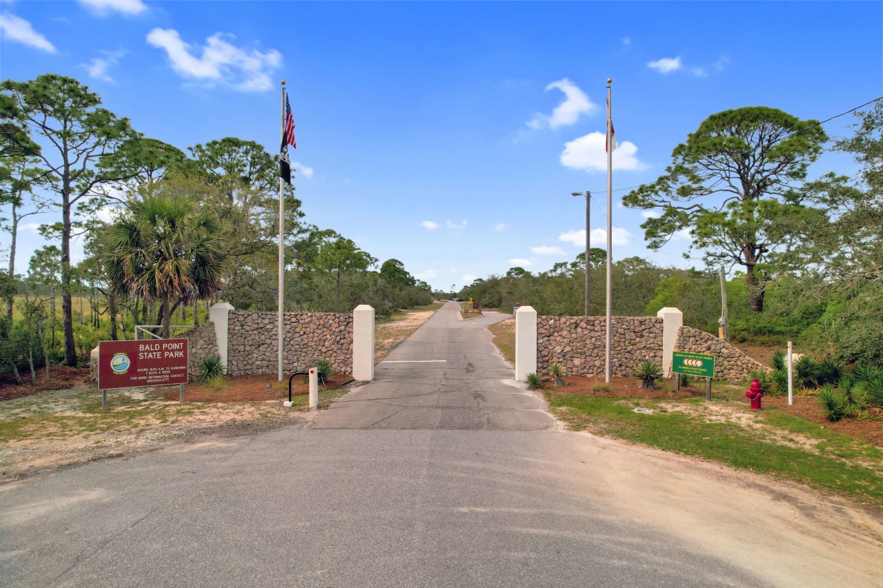 An entrance of Bald Point State Park with a paved road.