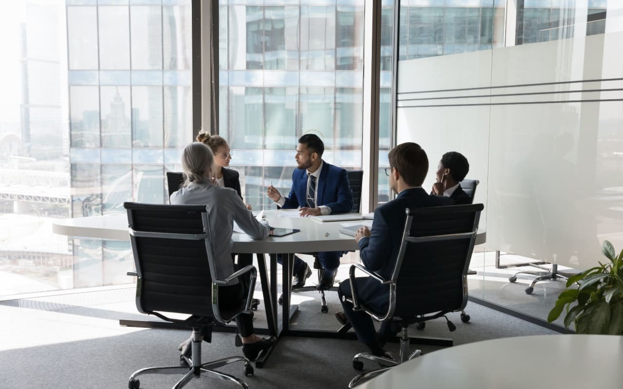 five people inside an office having a meeting