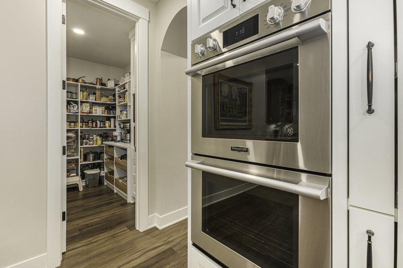 A stainless steel oven and pantry in a kitchen