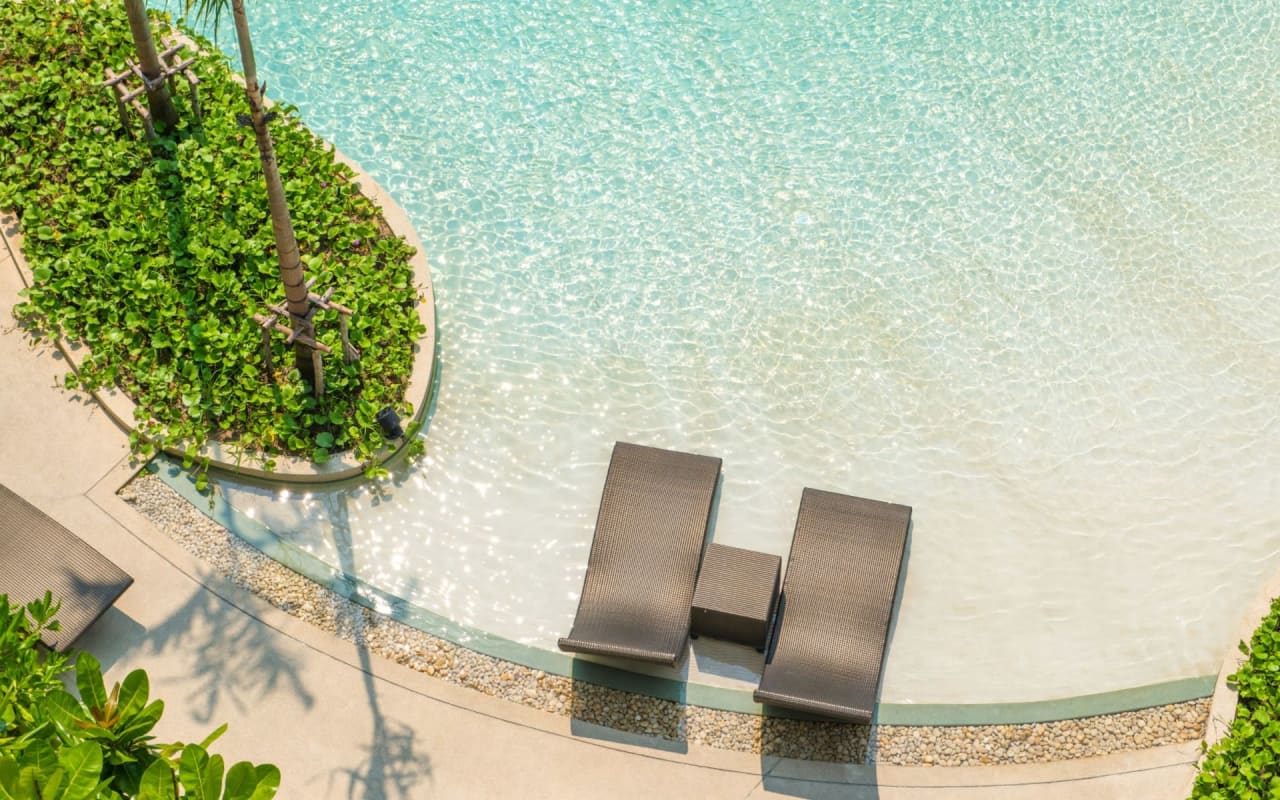 An aerial view of a luxurious pool area with two lounge chairs