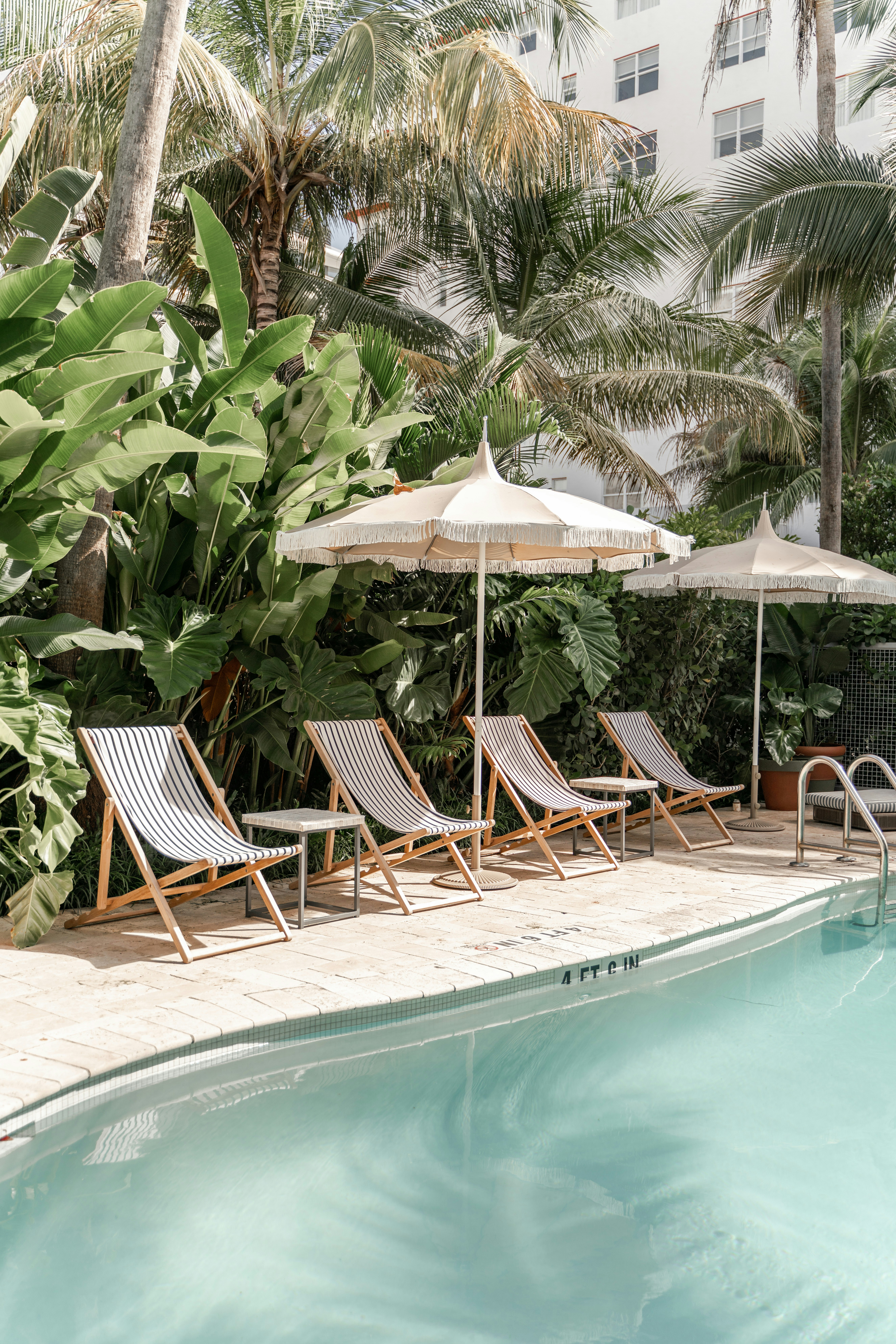 Outdoor poolside area with striped lounge chairs.