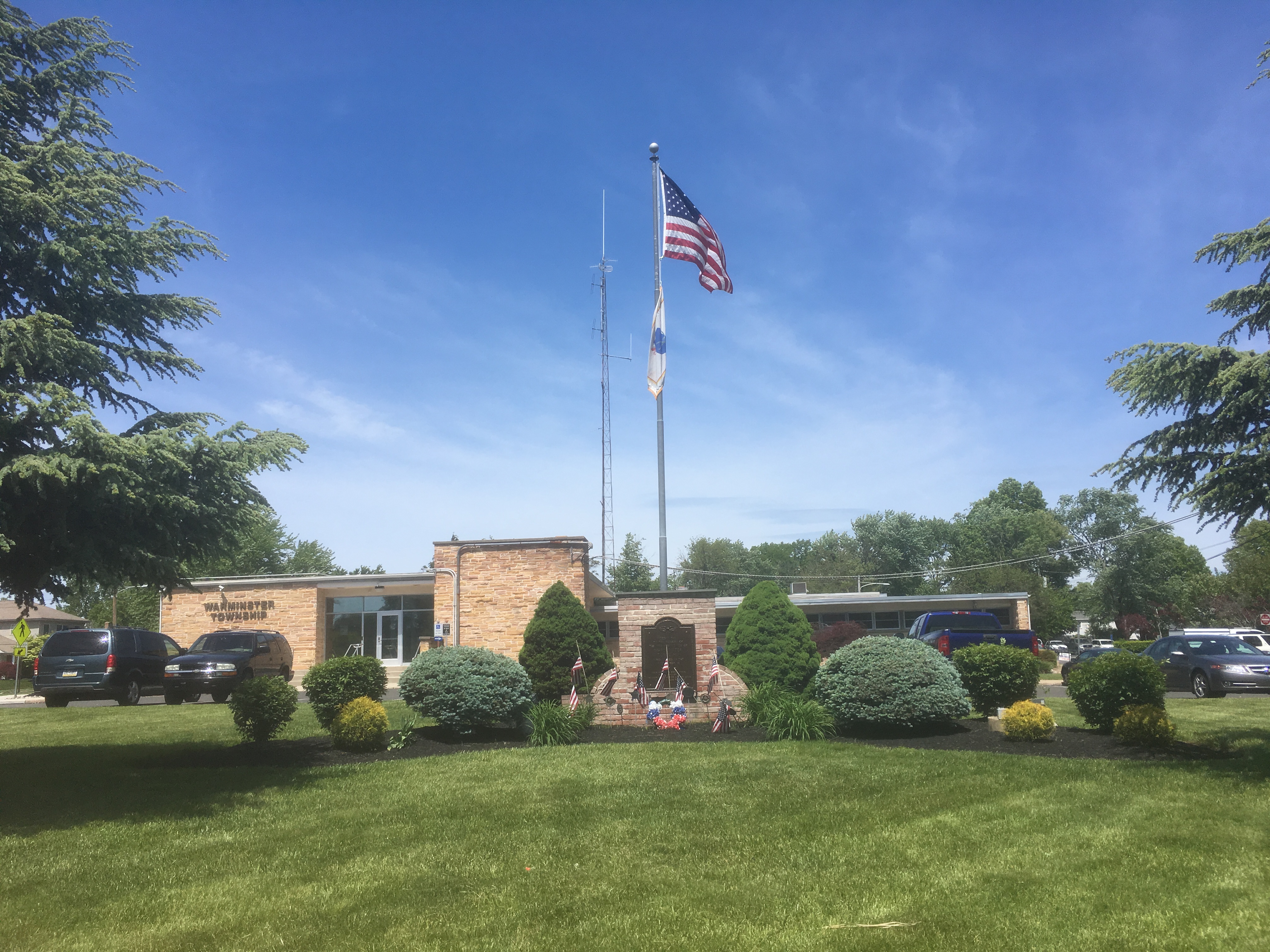 Warminster Township municipal building, with a flagpole and green lawn, in Warminster, Bucks County