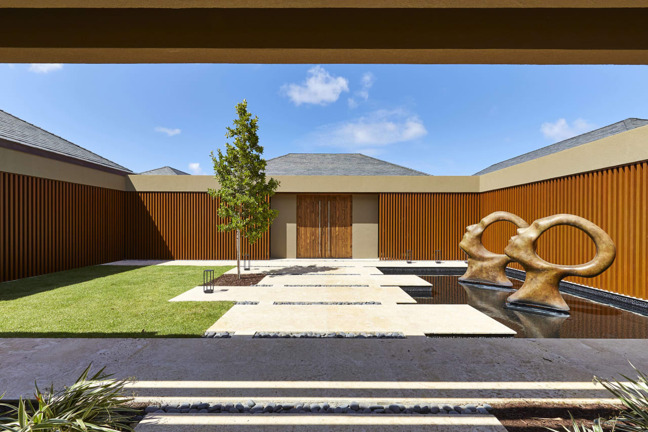 a large abstract sculpture made of white concrete in the middle of a stone courtyard