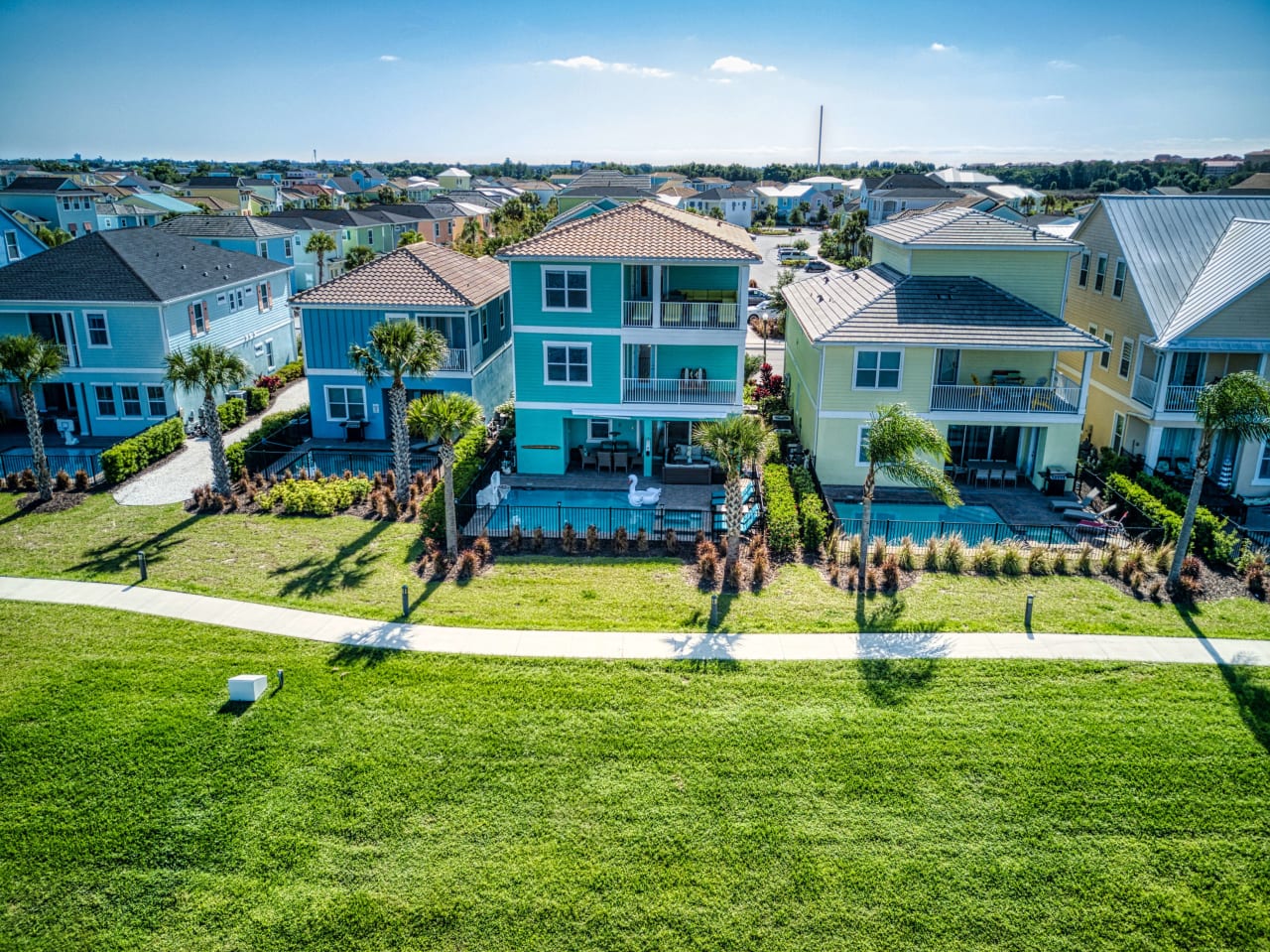 An aerial view of row colorful houses with walkways and palm trees