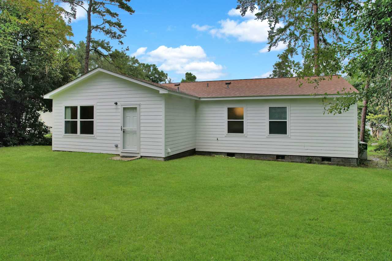 Photo of the rear of the home featuring a large window from the bonus room, to smaller windows from bedrooms, and a glass door leading into the at 1228 Winifred Drive, Tallahassee, Florida 32308