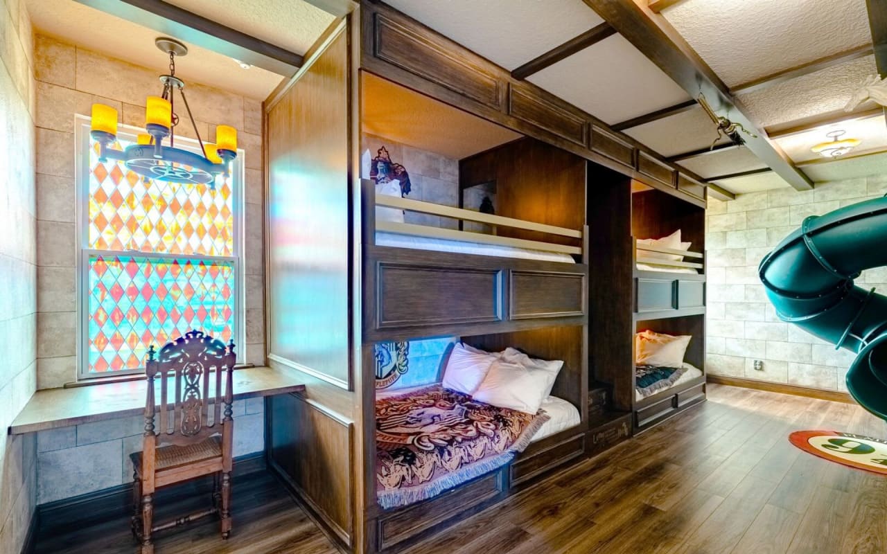 A bedroom designed for fun with bunk beds and a bright blue water slide that winds through the room.