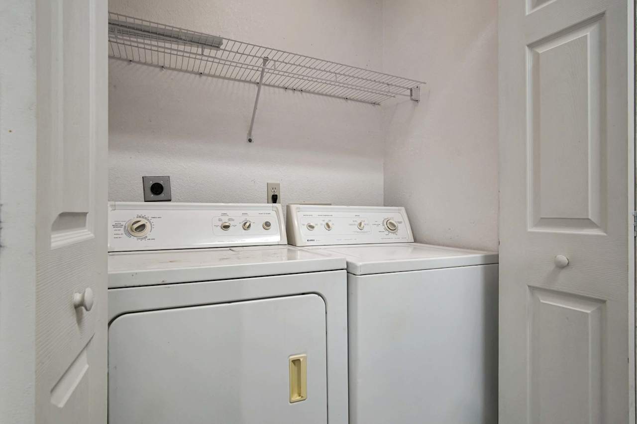 Photo of interior utility closet featuring built in shelving, a white washer, and a white Dryer  at 2709 Oak Park Court, Tallahassee, Florida 32308