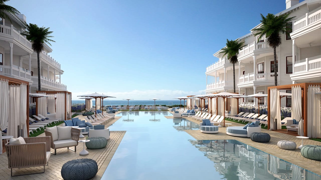 A large swimming pool in a hotel with ocean view