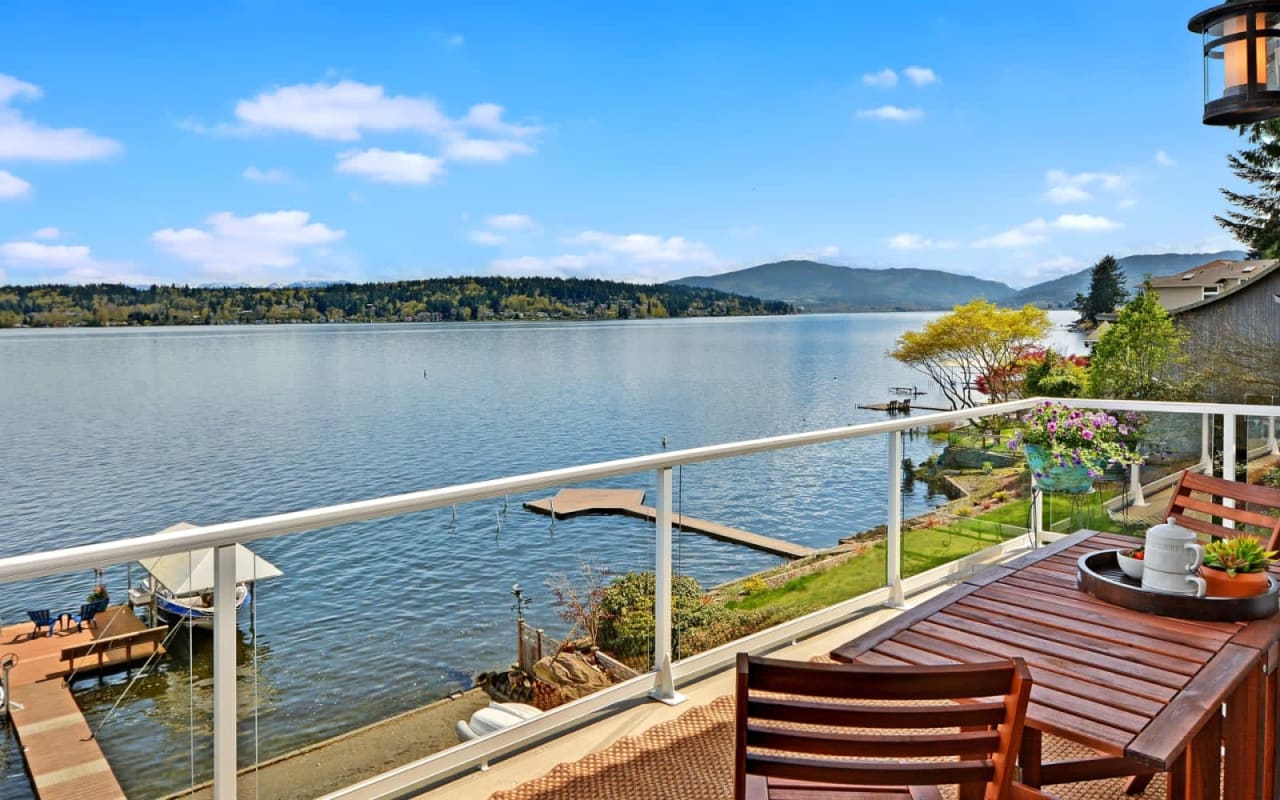 A table and chairs on a balcony overlooking a lake