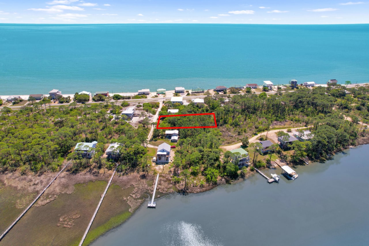 An aerial view of the coastal residential area, focusing on the water's edge and nearby houses.