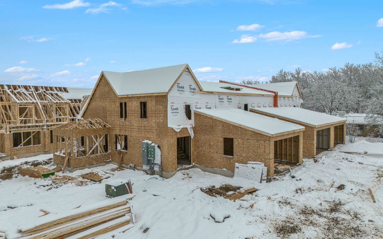 an under construction house framed out of wood in a snowy location