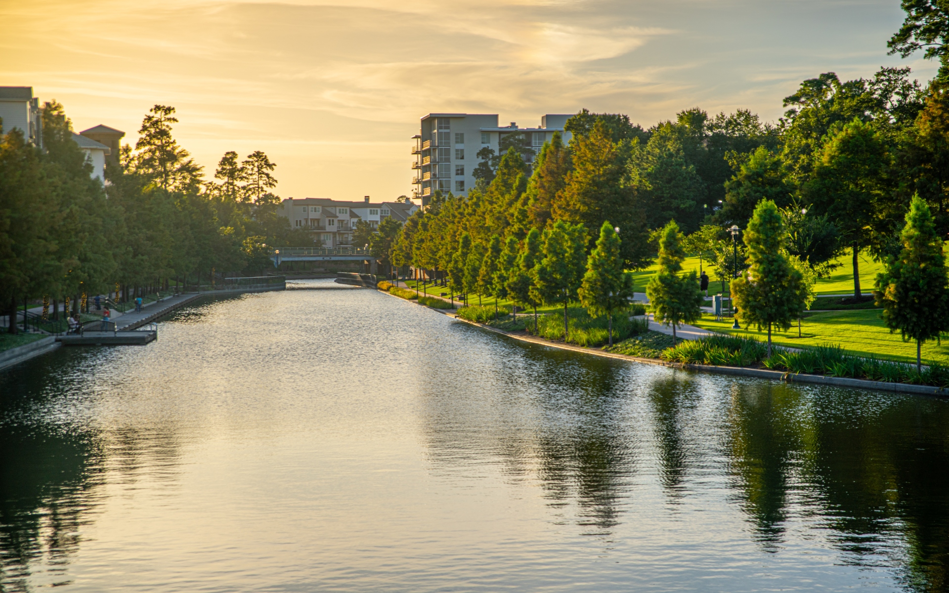 A welcoming entrance with brick steps, potted flowers, and large doors leading into a well-lit interior.