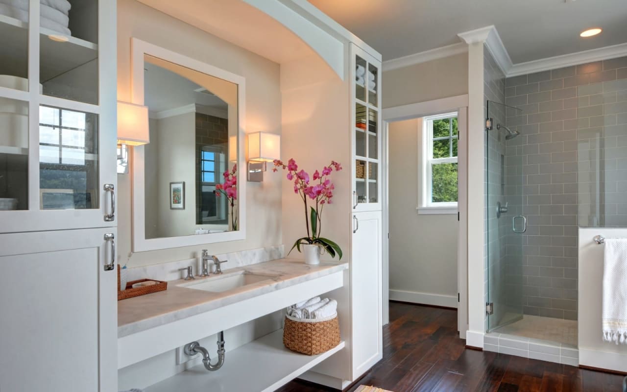 A modern bathroom with a sink, mirror, and shower