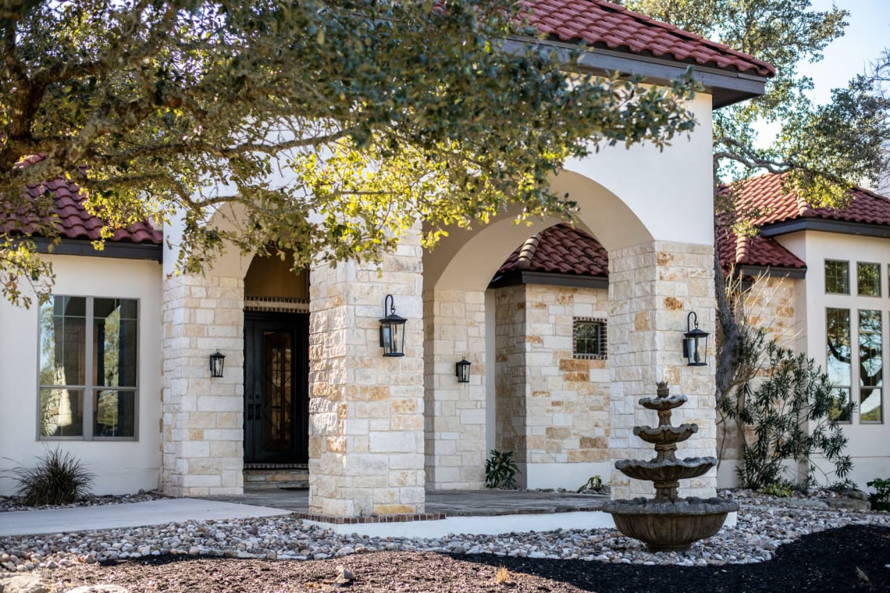 A house with a fountain in front of it.