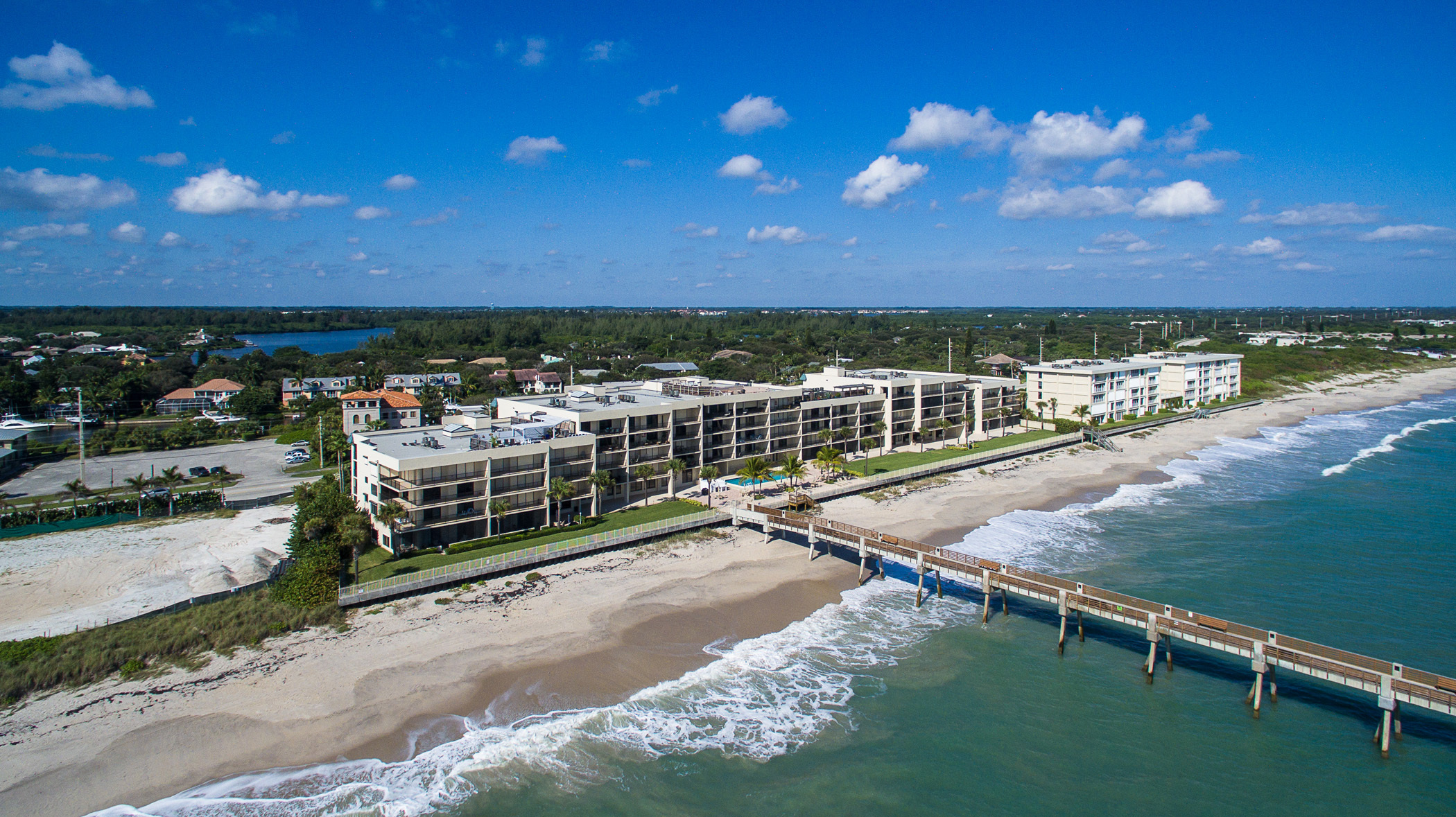 Aerial view of the Indian River Lagoon at Vero Beach, with a private deep-water marina, riverfront condominium residences, and mangrove islands