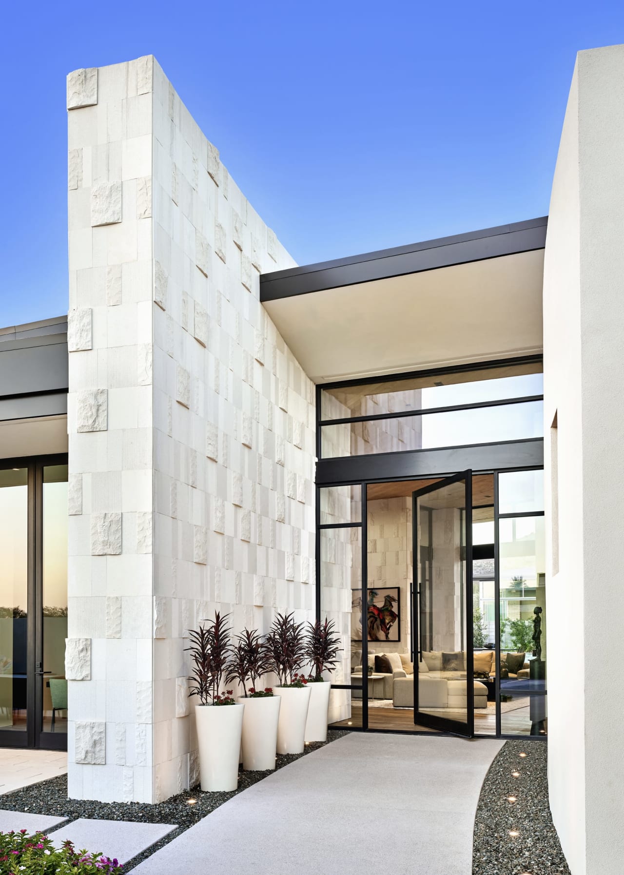 Radius shaped home with white stone and black accents