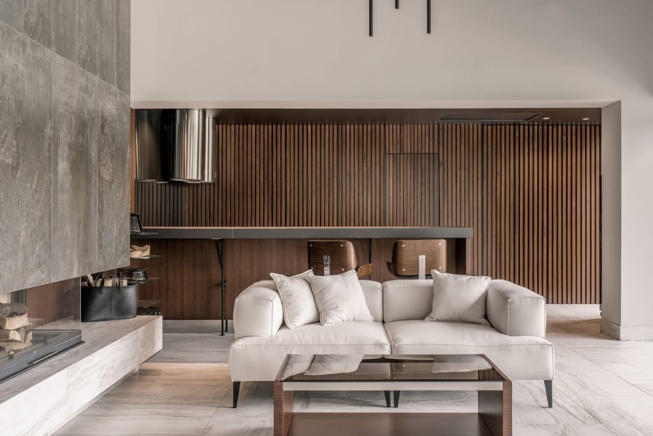 A living room with a large, gray sectional couch facing a fireplace.