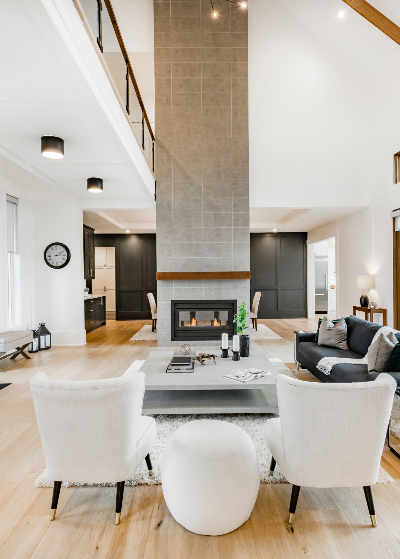 A cozy living room with a fireplace, leather chairs, a couch, and a wooden coffee table