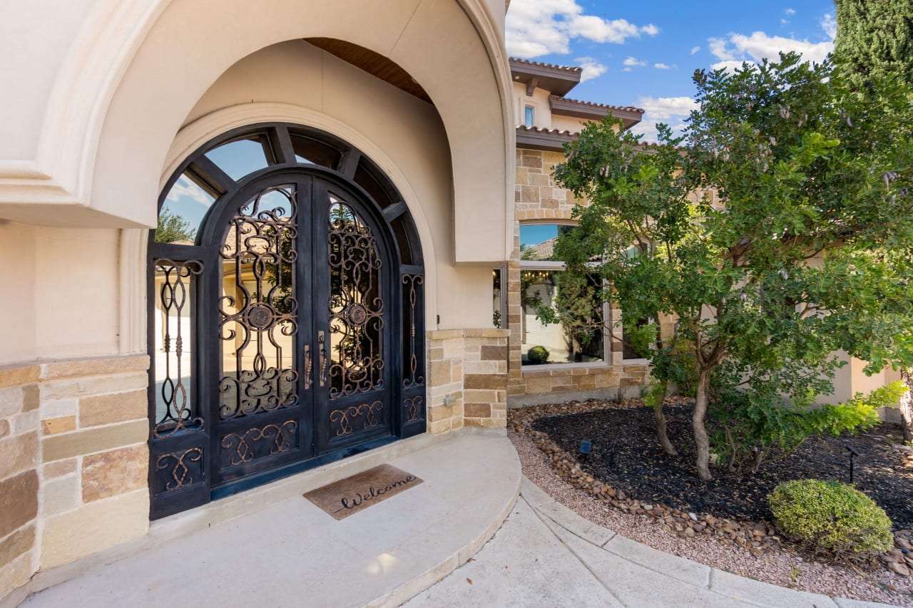 A wrought iron door with glass panels and a sidelight.