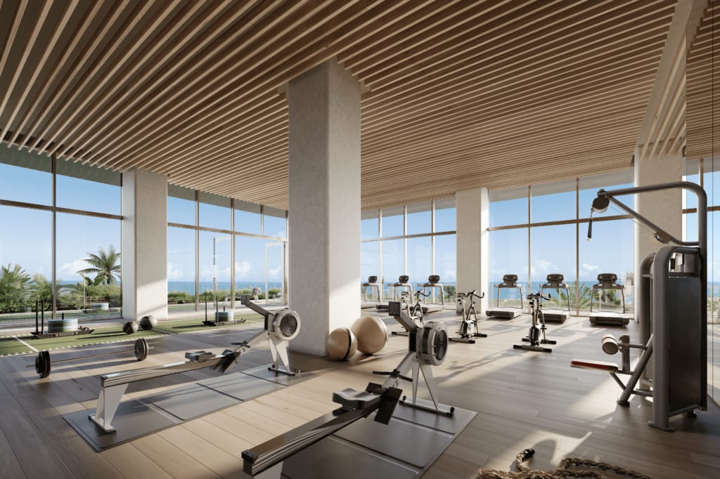 Large modern gym with floor to ceiling windows with ocean views