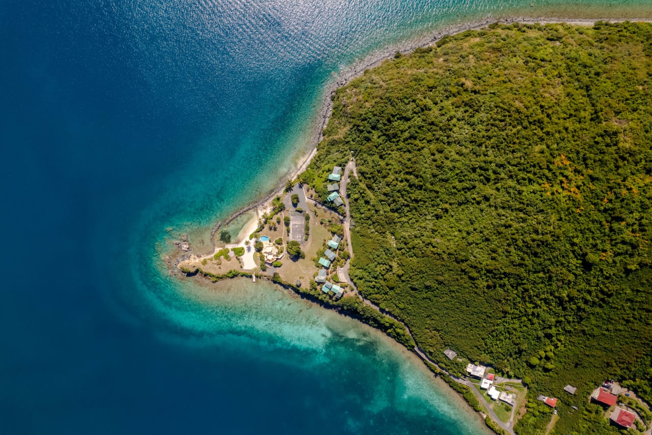 An aerial view of a small, tropical island with houses nestled amidst palm trees