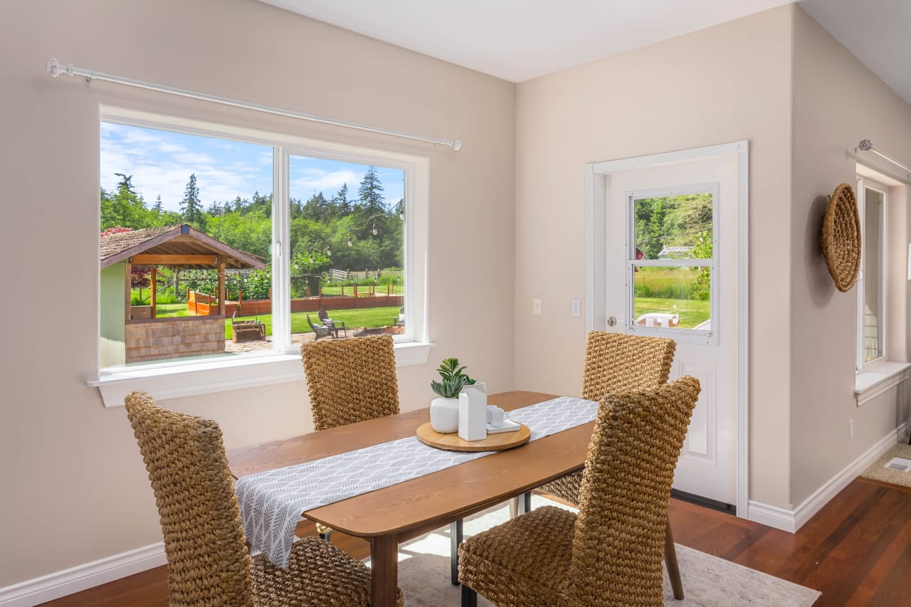 A dining room with a wooden table and wicker chairs