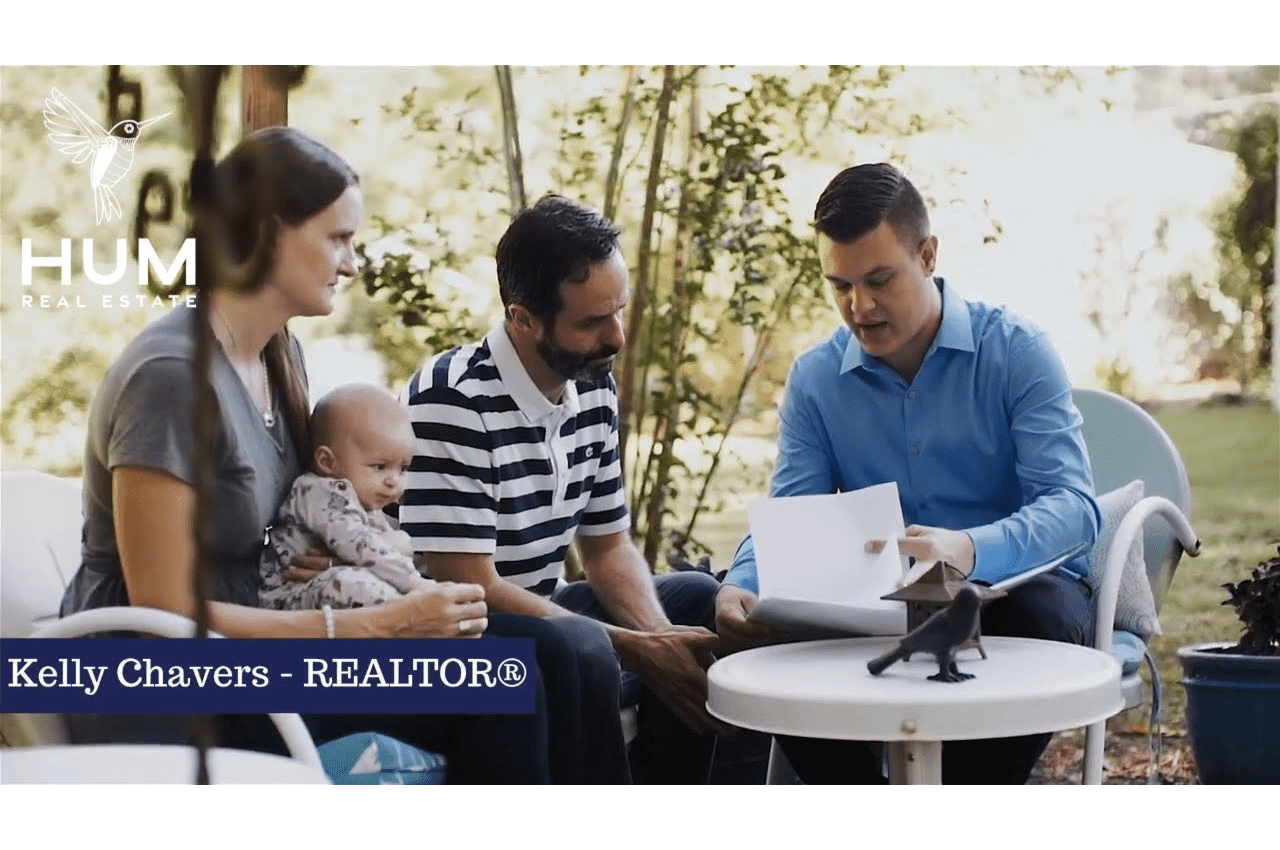 Kelly Chavers talking to couple with a baby, discussing about real estate.