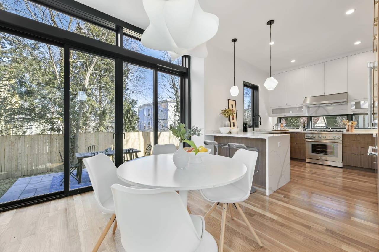 Modern kitchen with a round dining table and large sliding glass doors opening to the backyard.