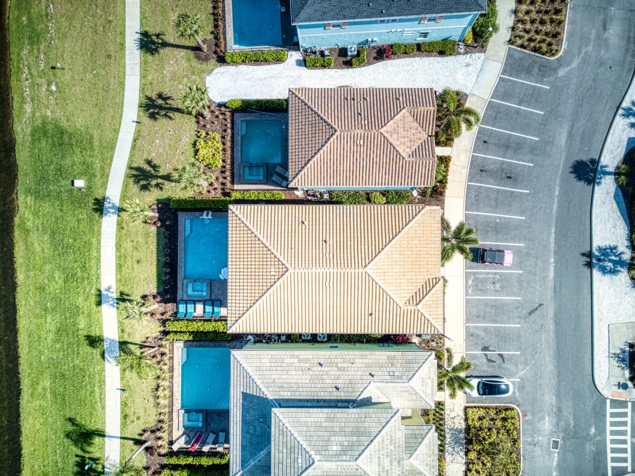 An aerial view of a houses with a rectangular swimming pool in the backyard.