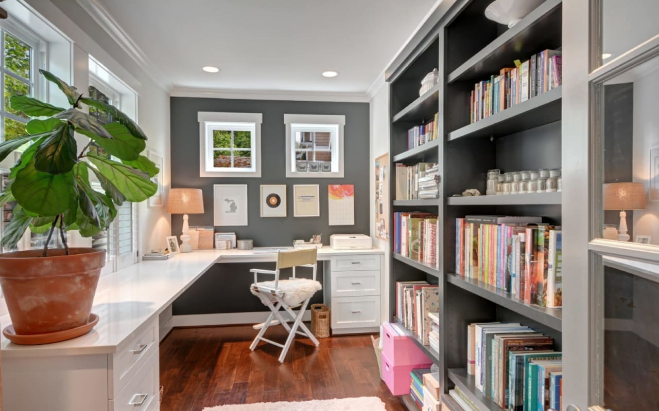 Desk setup in a home office with shelves and chair