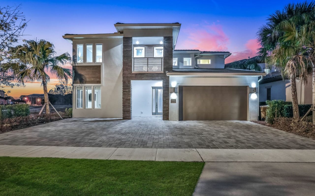 A white house with a two-car garage and a long driveway.