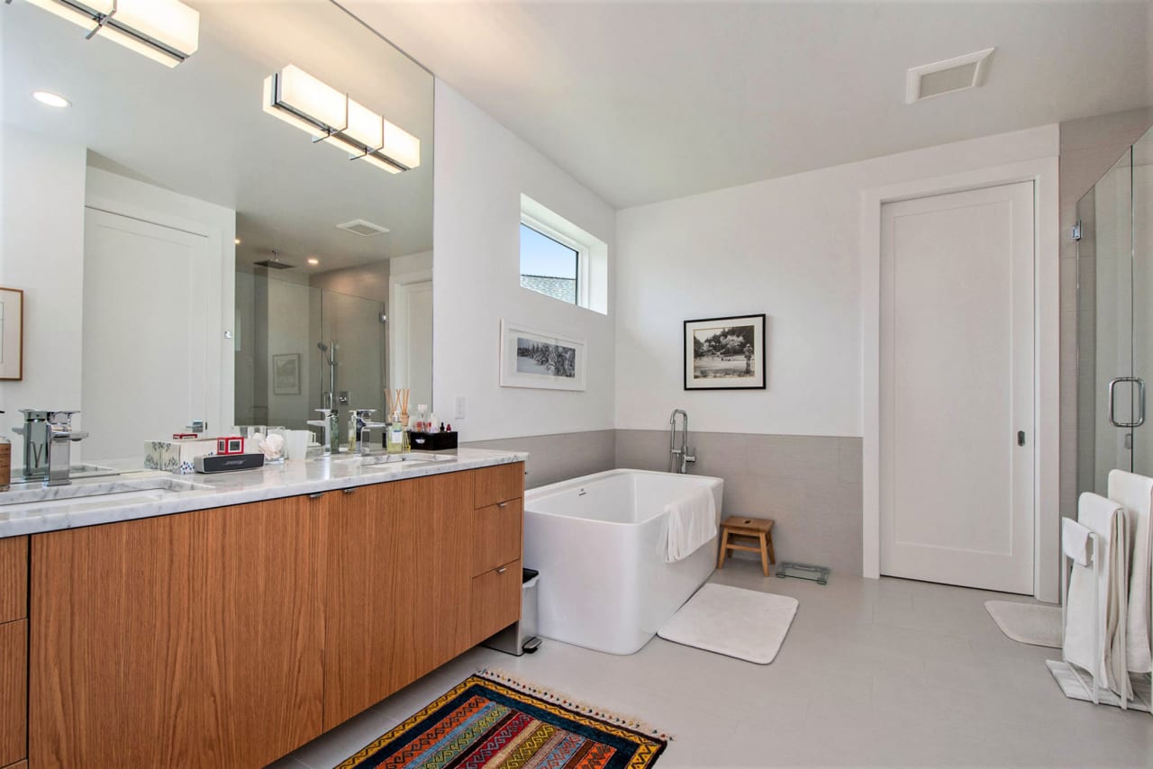 bathroom with a bath tub and large mirror