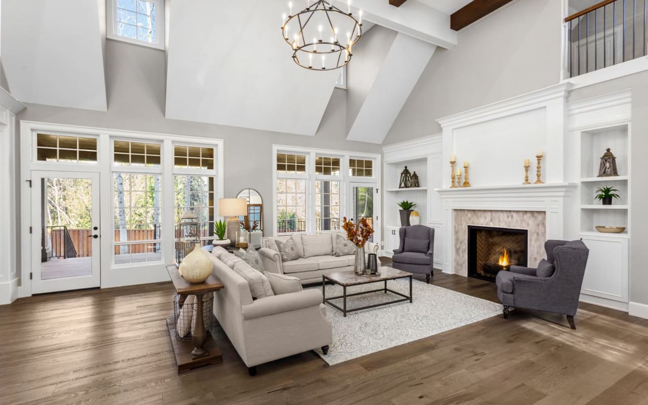 A well-lit living room with a comfortable-looking couch, chairs, and a fireplace