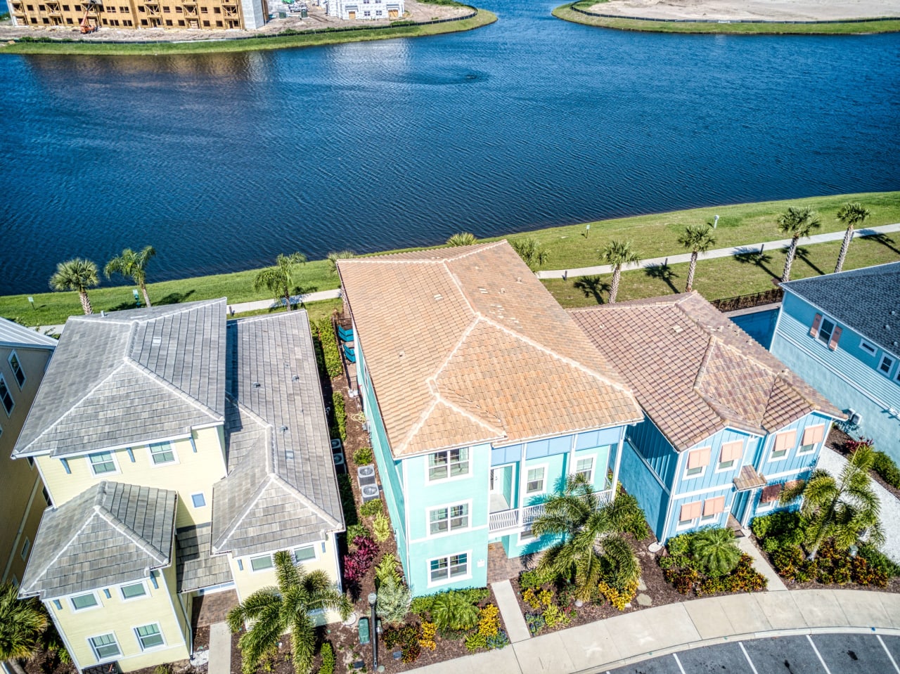 An aerial view of a suburban neighborhood with colorful houses lining a waterfront.