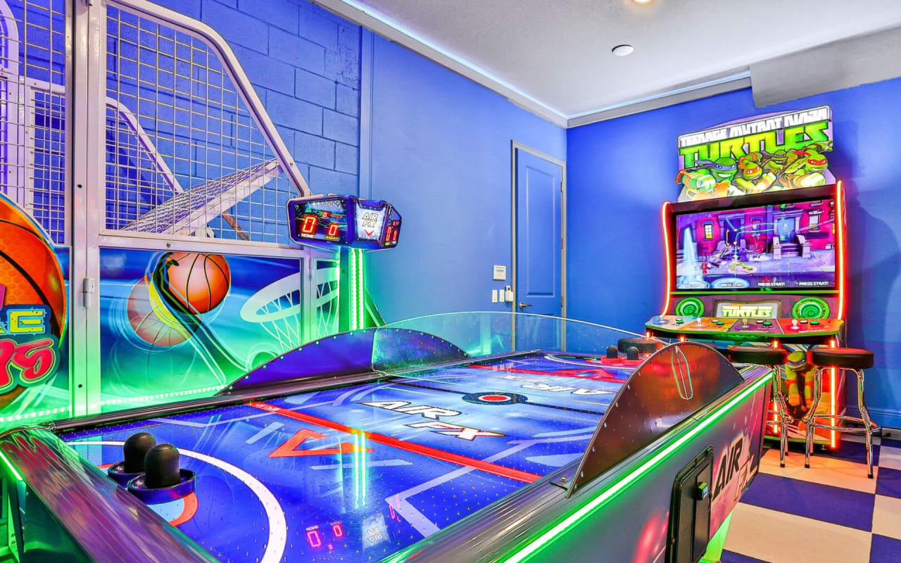 A game room with classic arcade games with teenage mutant ninja and an air hockey table