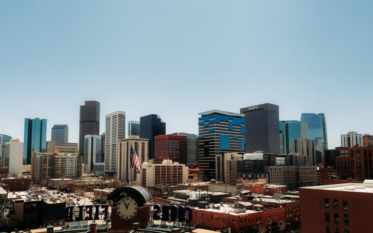 Denver skyline with a central clock tower and tall buildings on a clear day.