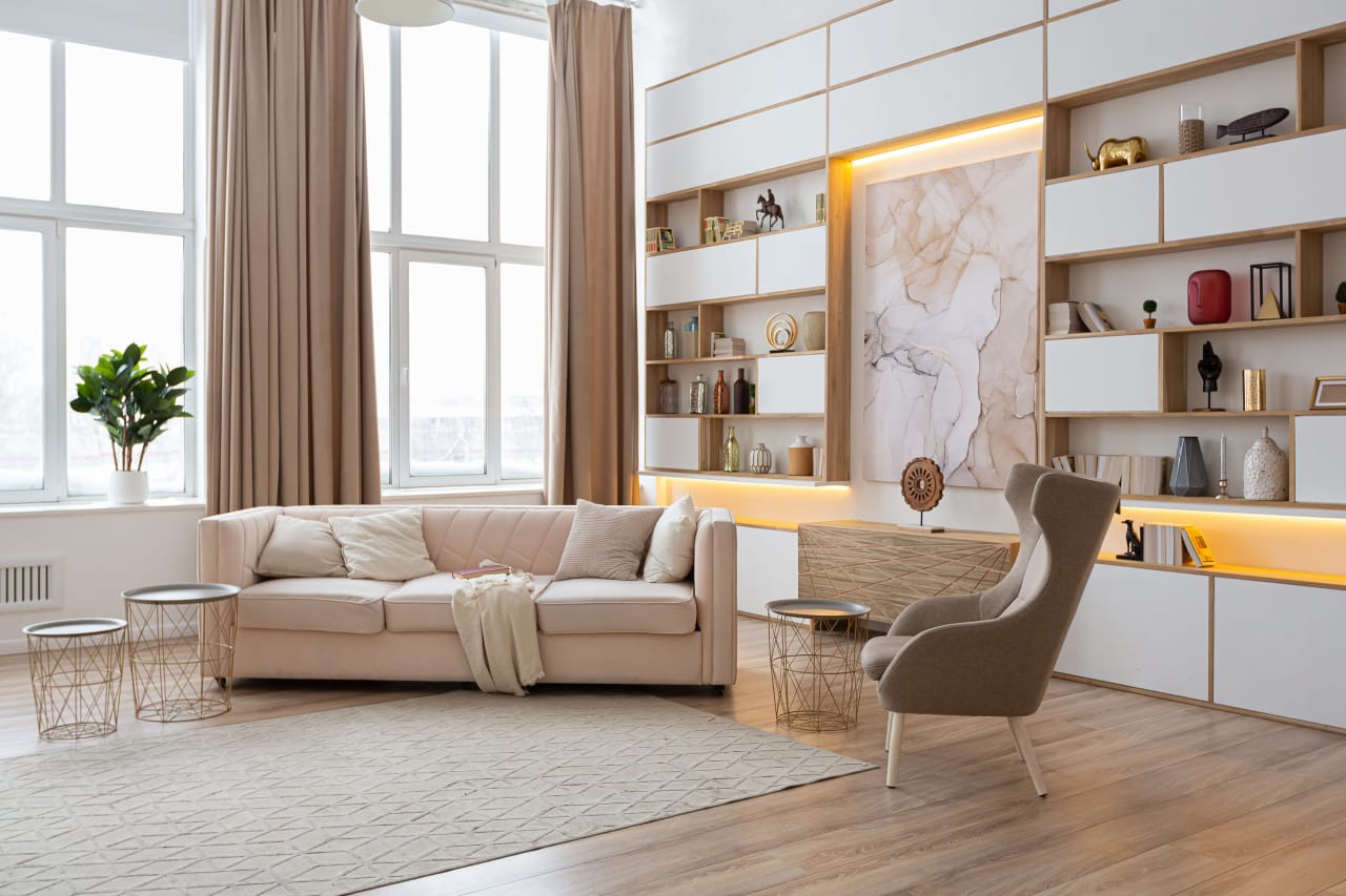 A living room with a pink couch, armchair, and a round coffee table.