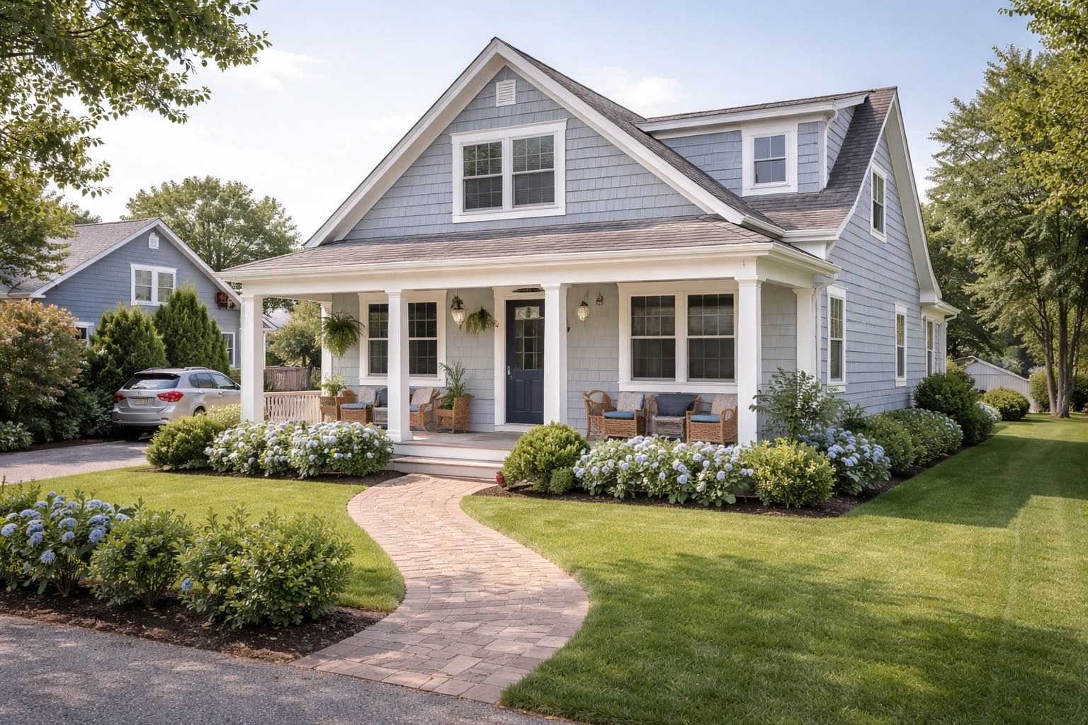 East Quogue home with blue shingles, white trim, and front porch