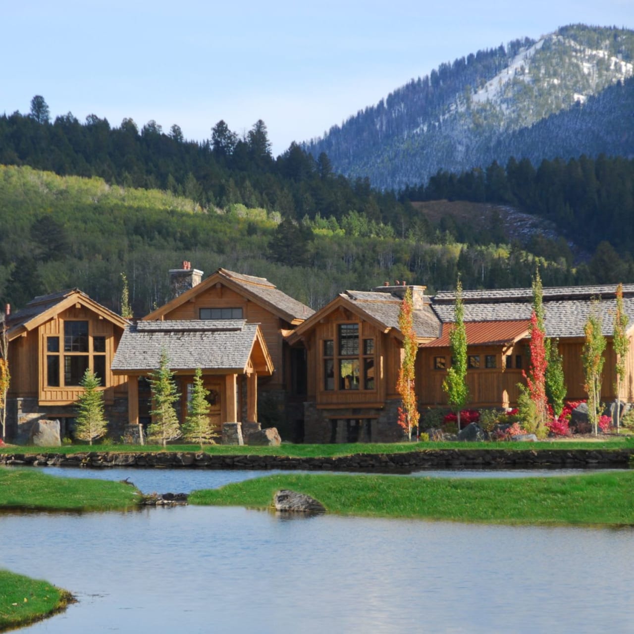 A large wooden house sitting next to a lake.