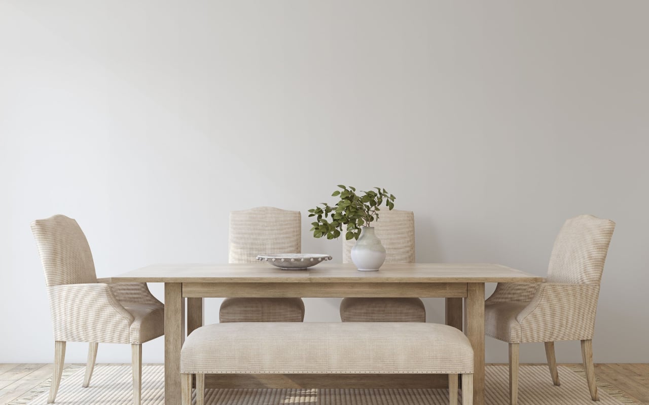 A dining room with a long wooden table and chairs.