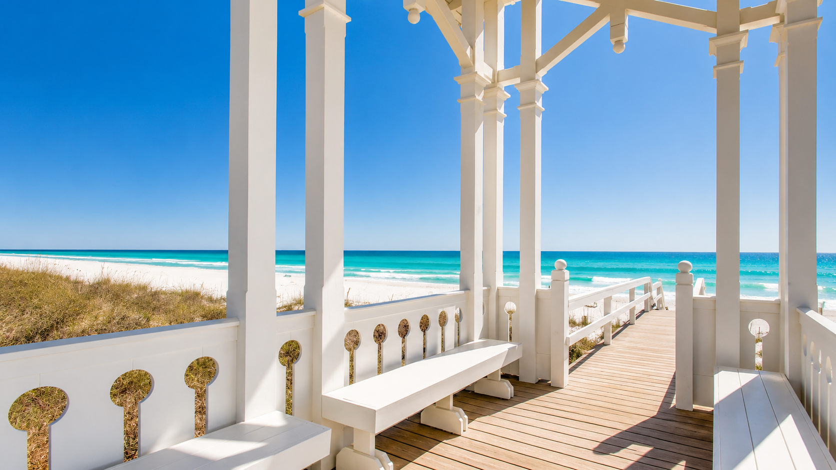 White beach pavilion with benches overlooking sand and turquoise Gulf water