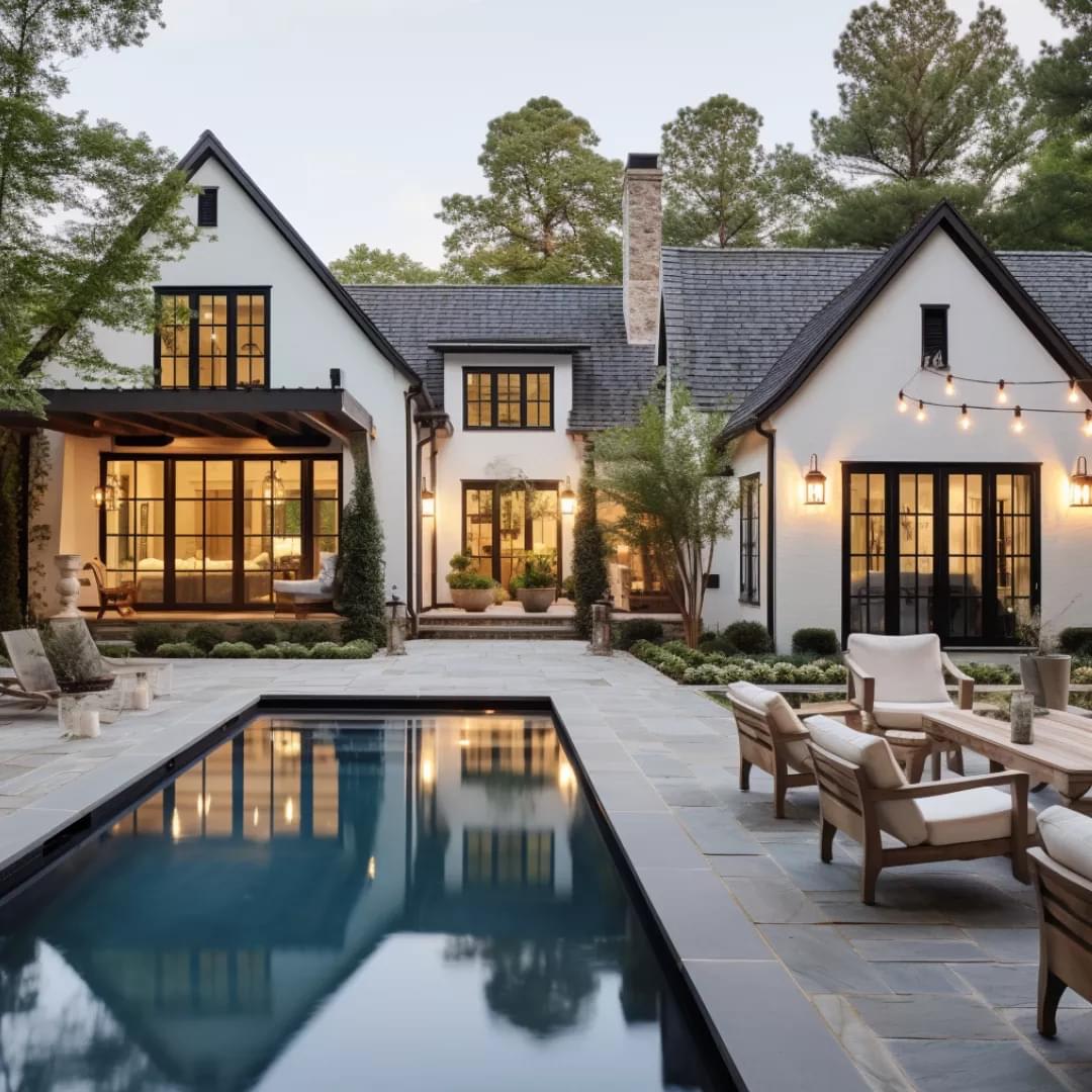 A white house with black windows and a swimming pool in the backyard